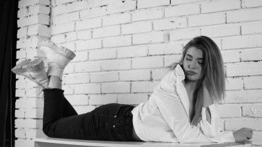 Stüdyoda uzun saçlı, uzun saçlı, siyah beyaz bir kadın poz veriyor..  