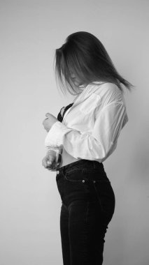 Stüdyoda uzun saçlı, uzun saçlı, siyah beyaz bir kadın poz veriyor..  