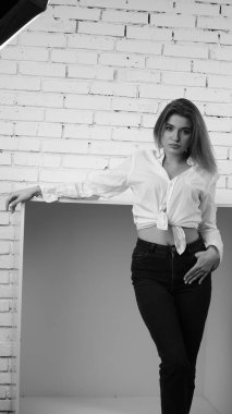 Stüdyoda uzun saçlı, uzun saçlı, siyah beyaz bir kadın poz veriyor..  