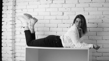 Stüdyoda uzun saçlı, uzun saçlı, siyah beyaz bir kadın poz veriyor..  