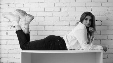 Stüdyoda uzun saçlı, uzun saçlı, siyah beyaz bir kadın poz veriyor..  