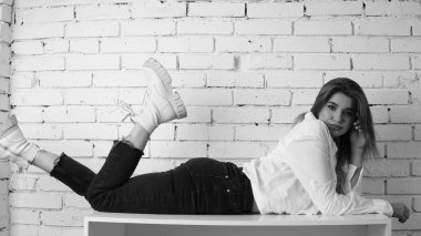 Stüdyoda uzun saçlı, uzun saçlı, siyah beyaz bir kadın poz veriyor..  