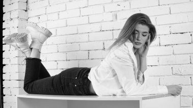 Stüdyoda uzun saçlı, uzun saçlı, siyah beyaz bir kadın poz veriyor..  