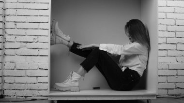 Stüdyoda uzun saçlı, uzun saçlı, siyah beyaz bir kadın poz veriyor..  