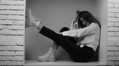 Stüdyoda uzun saçlı, uzun saçlı, siyah beyaz bir kadın poz veriyor..  