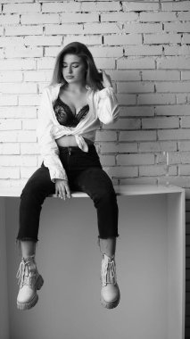 Stüdyoda uzun saçlı, uzun saçlı, siyah beyaz bir kadın poz veriyor..  