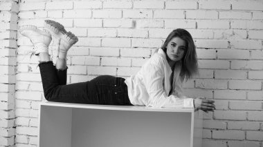 Stüdyoda uzun saçlı, uzun saçlı, siyah beyaz bir kadın poz veriyor..  