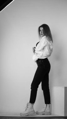 Stüdyoda uzun saçlı, uzun saçlı, siyah beyaz bir kadın poz veriyor..  