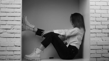 Stüdyoda uzun saçlı, uzun saçlı, siyah beyaz bir kadın poz veriyor..  