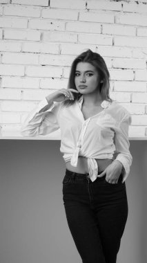 Stüdyoda uzun saçlı, uzun saçlı, siyah beyaz bir kadın poz veriyor..  