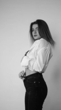 Stüdyoda uzun saçlı, uzun saçlı, siyah beyaz bir kadın poz veriyor..  