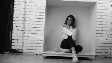 Stüdyoda uzun saçlı, uzun saçlı, siyah beyaz bir kadın poz veriyor..  