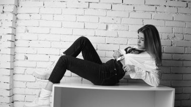 Stüdyoda uzun saçlı, uzun saçlı, siyah beyaz bir kadın poz veriyor..  