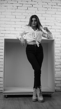 Stüdyoda uzun saçlı, uzun saçlı, siyah beyaz bir kadın poz veriyor..  