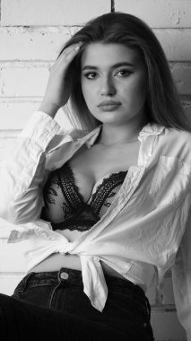 Stüdyoda uzun saçlı, uzun saçlı, siyah beyaz bir kadın poz veriyor..  