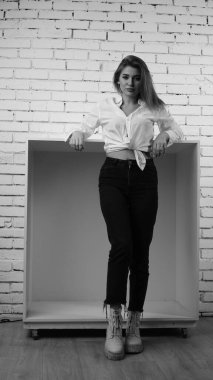 Stüdyoda uzun saçlı, uzun saçlı, siyah beyaz bir kadın poz veriyor..  