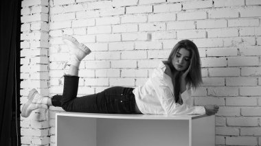 Stüdyoda uzun saçlı, uzun saçlı, siyah beyaz bir kadın poz veriyor..  