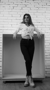 Stüdyoda uzun saçlı, uzun saçlı, siyah beyaz bir kadın poz veriyor..  