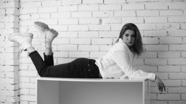 Stüdyoda uzun saçlı, uzun saçlı, siyah beyaz bir kadın poz veriyor..  