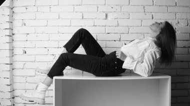 Stüdyoda uzun saçlı, uzun saçlı, siyah beyaz bir kadın poz veriyor..  