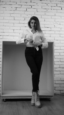 Stüdyoda uzun saçlı, uzun saçlı, siyah beyaz bir kadın poz veriyor..  