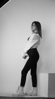 Stüdyoda uzun saçlı, uzun saçlı, siyah beyaz bir kadın poz veriyor..  