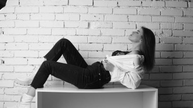 Stüdyoda uzun saçlı, uzun saçlı, siyah beyaz bir kadın poz veriyor..  