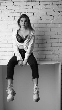 Stüdyoda uzun saçlı, uzun saçlı, siyah beyaz bir kadın poz veriyor..  