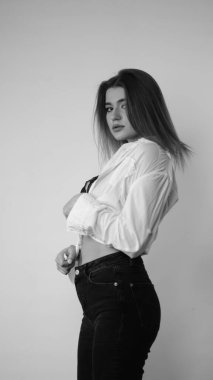 Stüdyoda uzun saçlı, uzun saçlı, siyah beyaz bir kadın poz veriyor..  