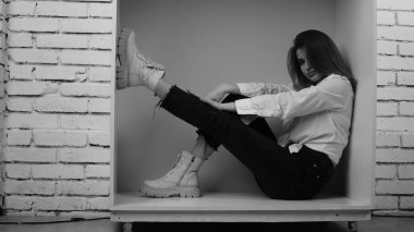 Stüdyoda uzun saçlı, uzun saçlı, siyah beyaz bir kadın poz veriyor..  