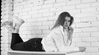 Stüdyoda uzun saçlı, uzun saçlı, siyah beyaz bir kadın poz veriyor..  