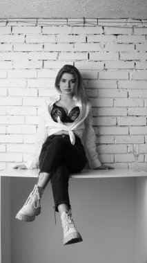 Stüdyoda uzun saçlı, uzun saçlı, siyah beyaz bir kadın poz veriyor..  