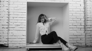 Stüdyoda uzun saçlı, uzun saçlı, siyah beyaz bir kadın poz veriyor..  