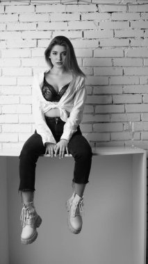 Stüdyoda uzun saçlı, uzun saçlı, siyah beyaz bir kadın poz veriyor..  