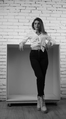 Stüdyoda uzun saçlı, uzun saçlı, siyah beyaz bir kadın poz veriyor..  