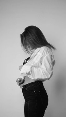 Stüdyoda uzun saçlı, uzun saçlı, siyah beyaz bir kadın poz veriyor..  