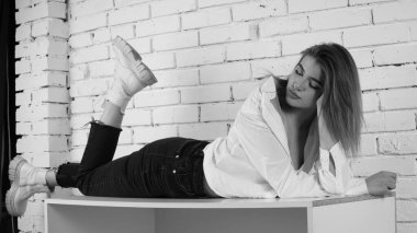 Stüdyoda uzun saçlı, uzun saçlı, siyah beyaz bir kadın poz veriyor..  