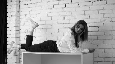 Stüdyoda uzun saçlı, uzun saçlı, siyah beyaz bir kadın poz veriyor..  