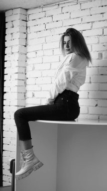 Stüdyoda uzun saçlı, uzun saçlı, siyah beyaz bir kadın poz veriyor..  