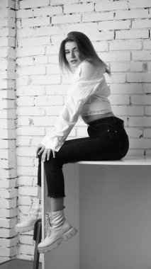 Stüdyoda uzun saçlı, uzun saçlı, siyah beyaz bir kadın poz veriyor..  