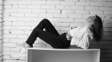 Stüdyoda uzun saçlı, uzun saçlı, siyah beyaz bir kadın poz veriyor..  