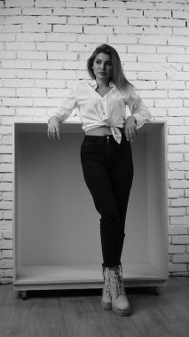 Stüdyoda uzun saçlı, uzun saçlı, siyah beyaz bir kadın poz veriyor..  