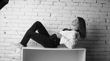 Stüdyoda uzun saçlı, uzun saçlı, siyah beyaz bir kadın poz veriyor..  