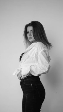 Stüdyoda uzun saçlı, uzun saçlı, siyah beyaz bir kadın poz veriyor..  