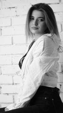 Stüdyoda uzun saçlı, uzun saçlı, siyah beyaz bir kadın poz veriyor..  