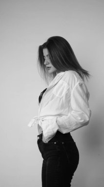 Stüdyoda uzun saçlı, uzun saçlı, siyah beyaz bir kadın poz veriyor..  