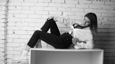 Stüdyoda uzun saçlı, uzun saçlı, siyah beyaz bir kadın poz veriyor..  