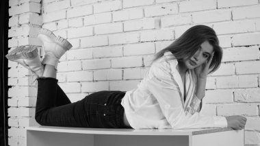 Stüdyoda uzun saçlı, uzun saçlı, siyah beyaz bir kadın poz veriyor..  