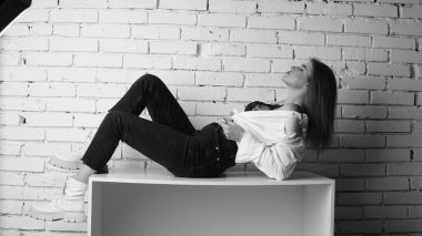 Stüdyoda uzun saçlı, uzun saçlı, siyah beyaz bir kadın poz veriyor..  