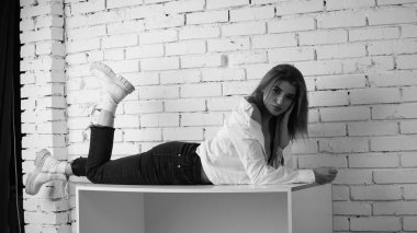 Stüdyoda uzun saçlı, uzun saçlı, siyah beyaz bir kadın poz veriyor..  